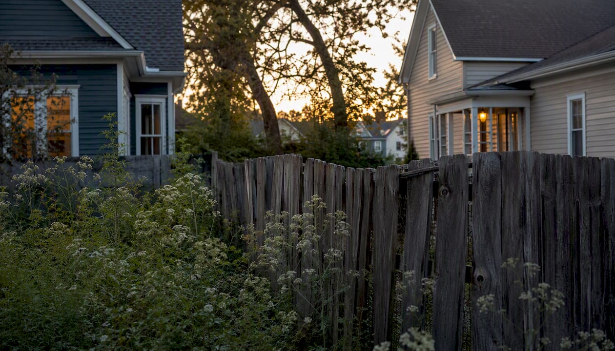 Aged wooden fence marking property boundary