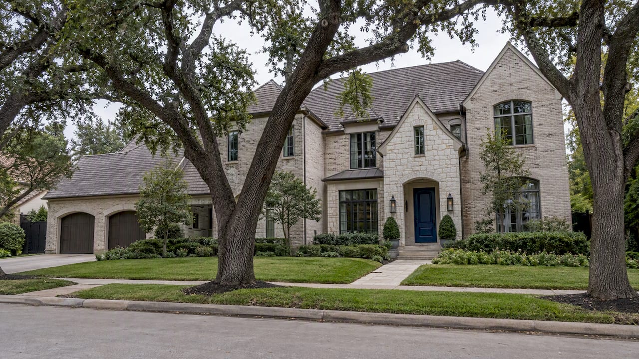 Luxury home beneath mature Houston oak trees